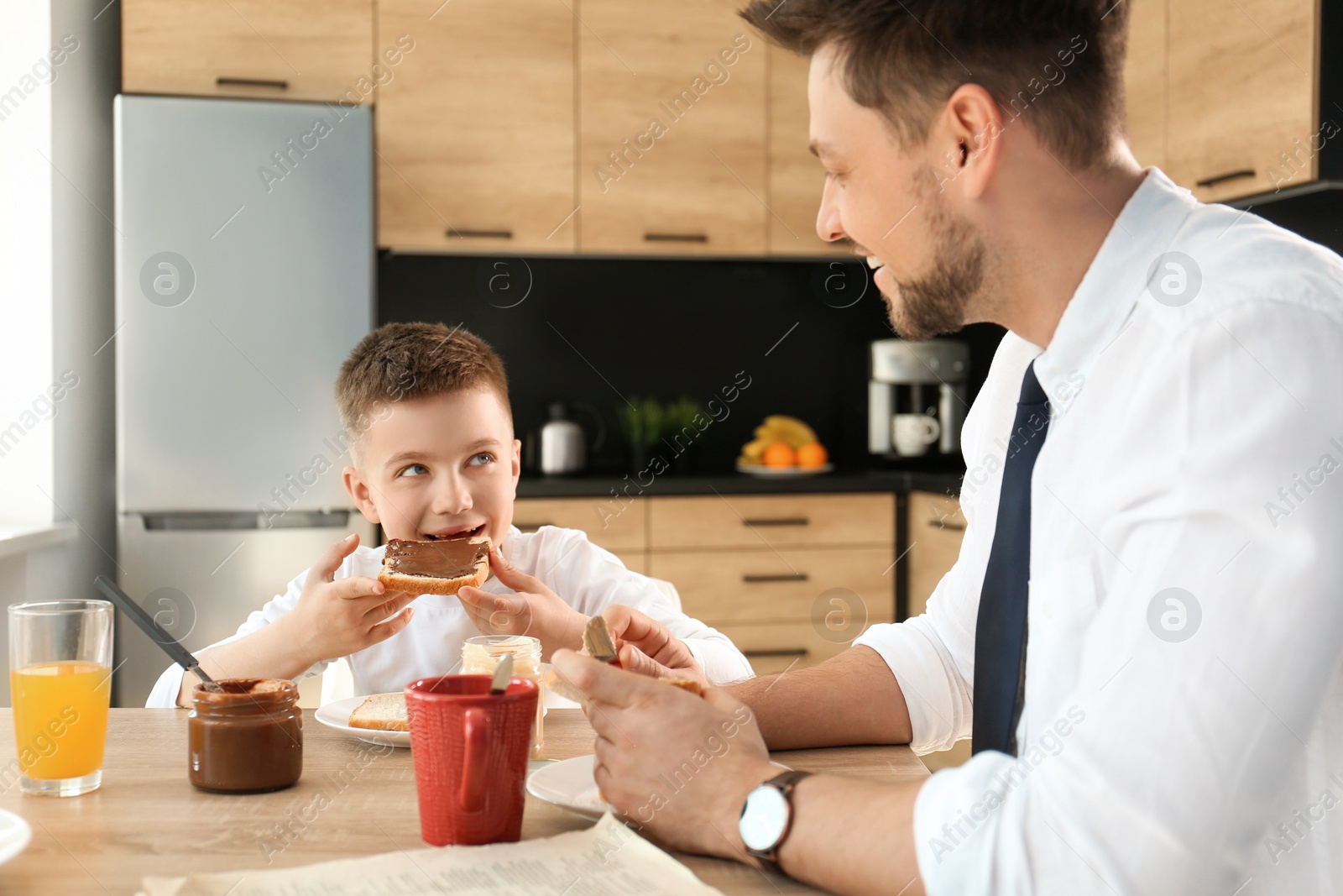 Photo of Dad and son having breakfast together in kitchen