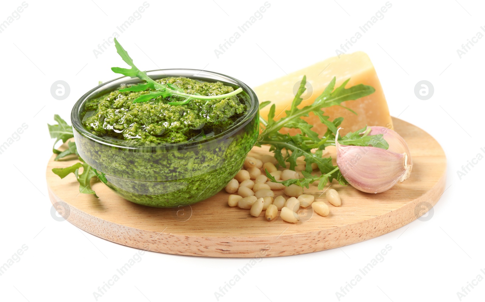 Photo of Bowl of tasty arugula pesto and ingredients on white background