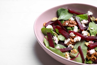 Delicious beet salad served on white wooden table, closeup. Space for text