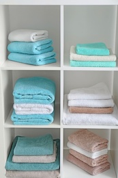 Photo of Clean towels on shelves in bathroom