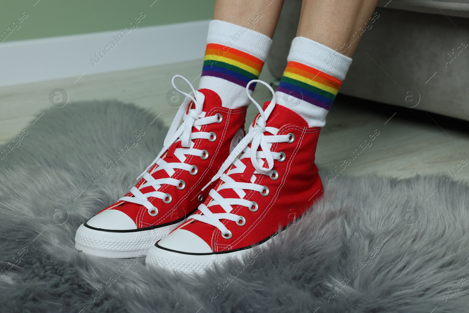 Photo of Woman in stylish gumshoes on floor, closeup