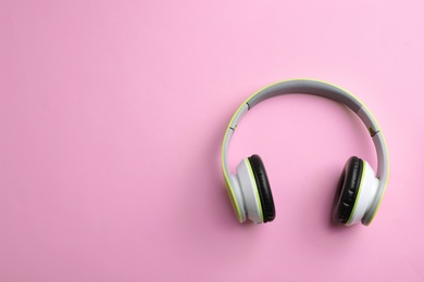 Photo of Wireless headphones on color background, top view. Space for text