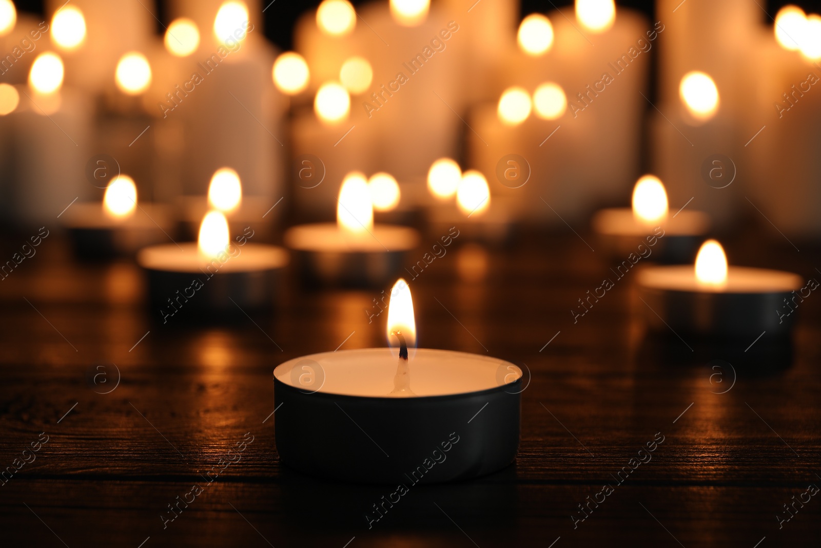 Photo of Burning candles on dark surface. Memory day