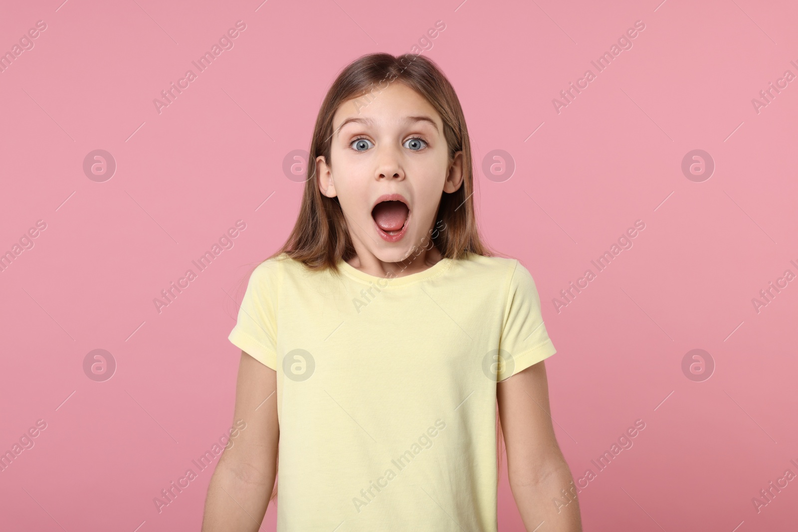 Photo of Portrait of surprised girl on pink background