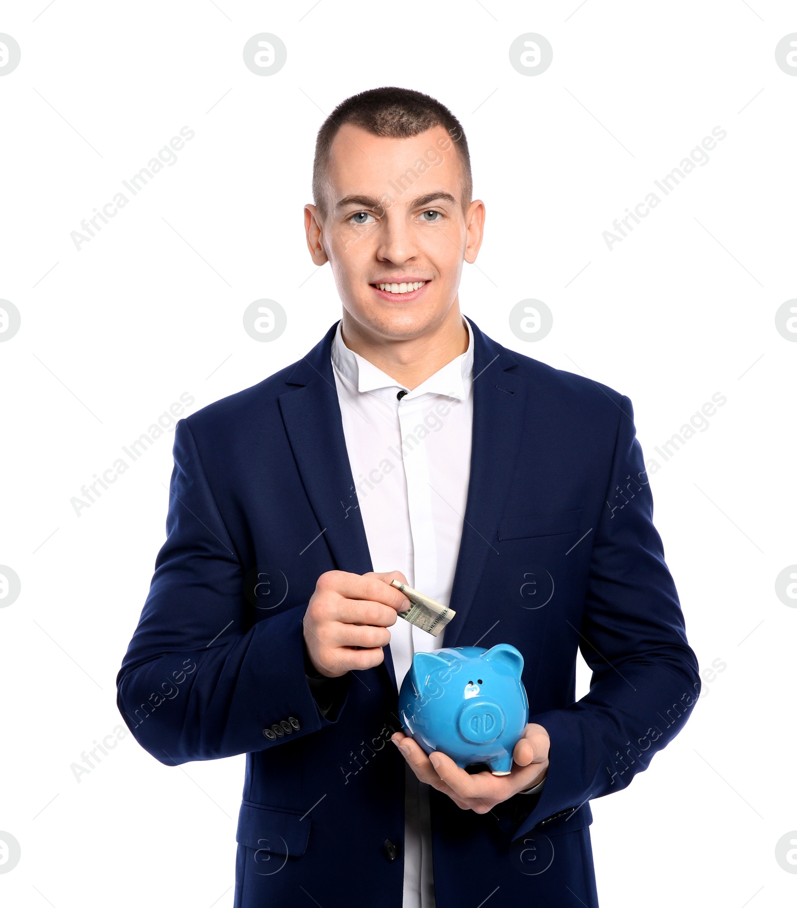 Photo of Young businessman putting money into piggy bank on white background