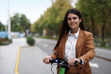 Photo of Businesswoman with modern electric kick scooter on city street, space for text