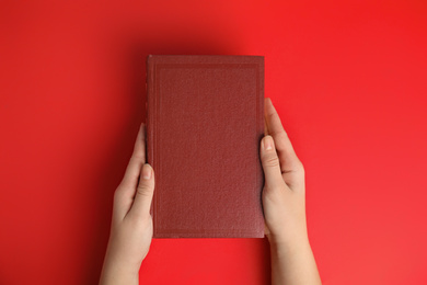 Photo of Woman with book on red background, top view. Space for design