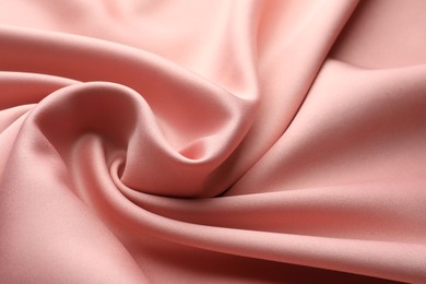 Photo of Crumpled pink silk fabric as background, closeup