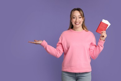 Happy young woman with passport and ticket on purple background, space for text