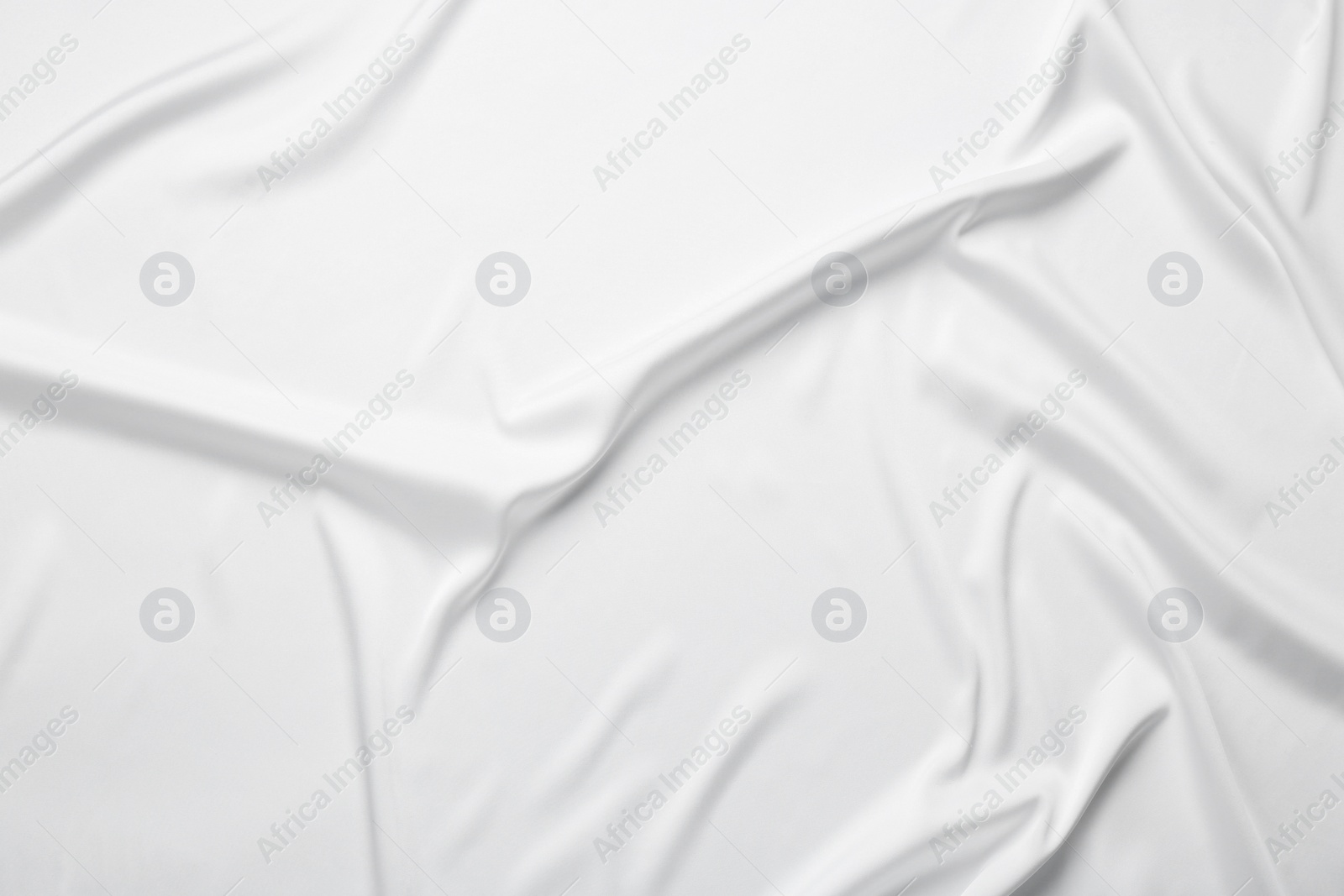 Photo of Texture of white crumpled silk fabric as background, top view