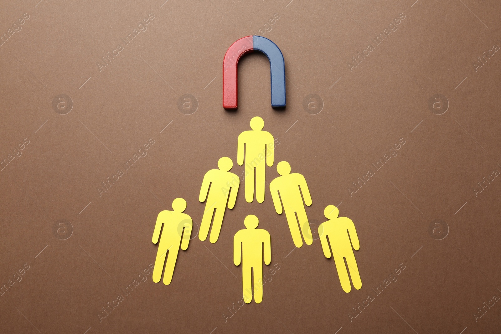 Photo of Magnet attracting paper people on color background, flat lay. Marketing concept