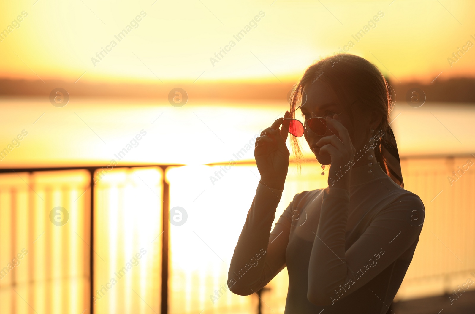 Photo of Silhouette of young woman outdoors at sunset