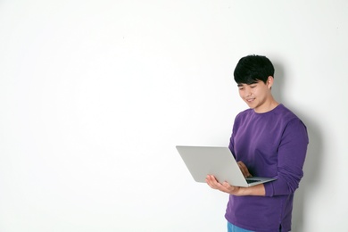 Photo of Man in casual clothes with laptop on light background