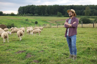 Smiling man on pasture at farm. Space for text