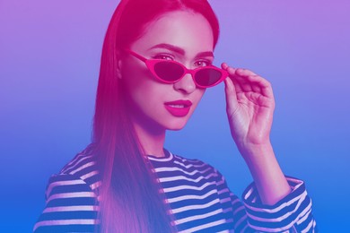 Image of Portrait of beautiful woman with sunglasses in neon lights