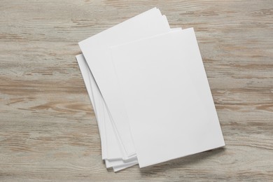 White paper sheets on wooden table, top view