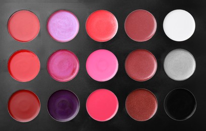 Photo of Cream lipstick palette as background, top view. Professional cosmetic product