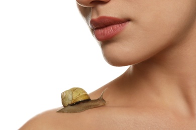 Photo of Beautiful young woman with snail on her body against white background, closeup