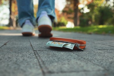 Woman lost her purse on pavement outdoors, selective focus