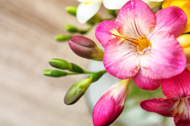 Photo of Beautiful freesia flowers on blurred background, closeup