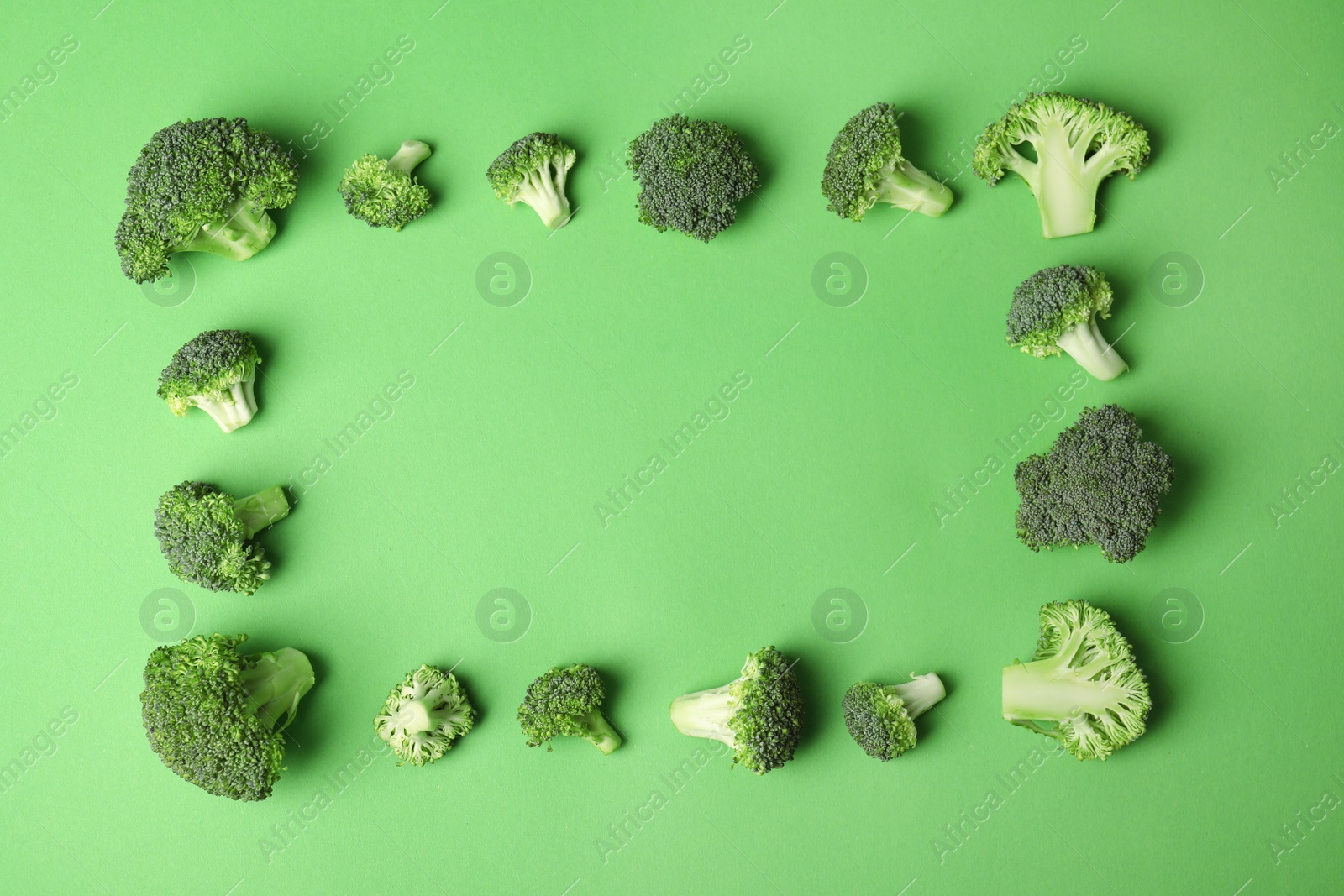 Photo of Flat lay composition with fresh green broccoli on color background. Space for text