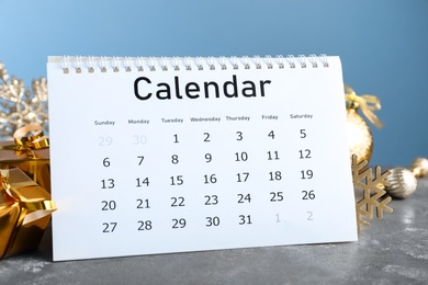 Photo of Flip calendar and Christmas decor on grey stone table. Holiday countdown