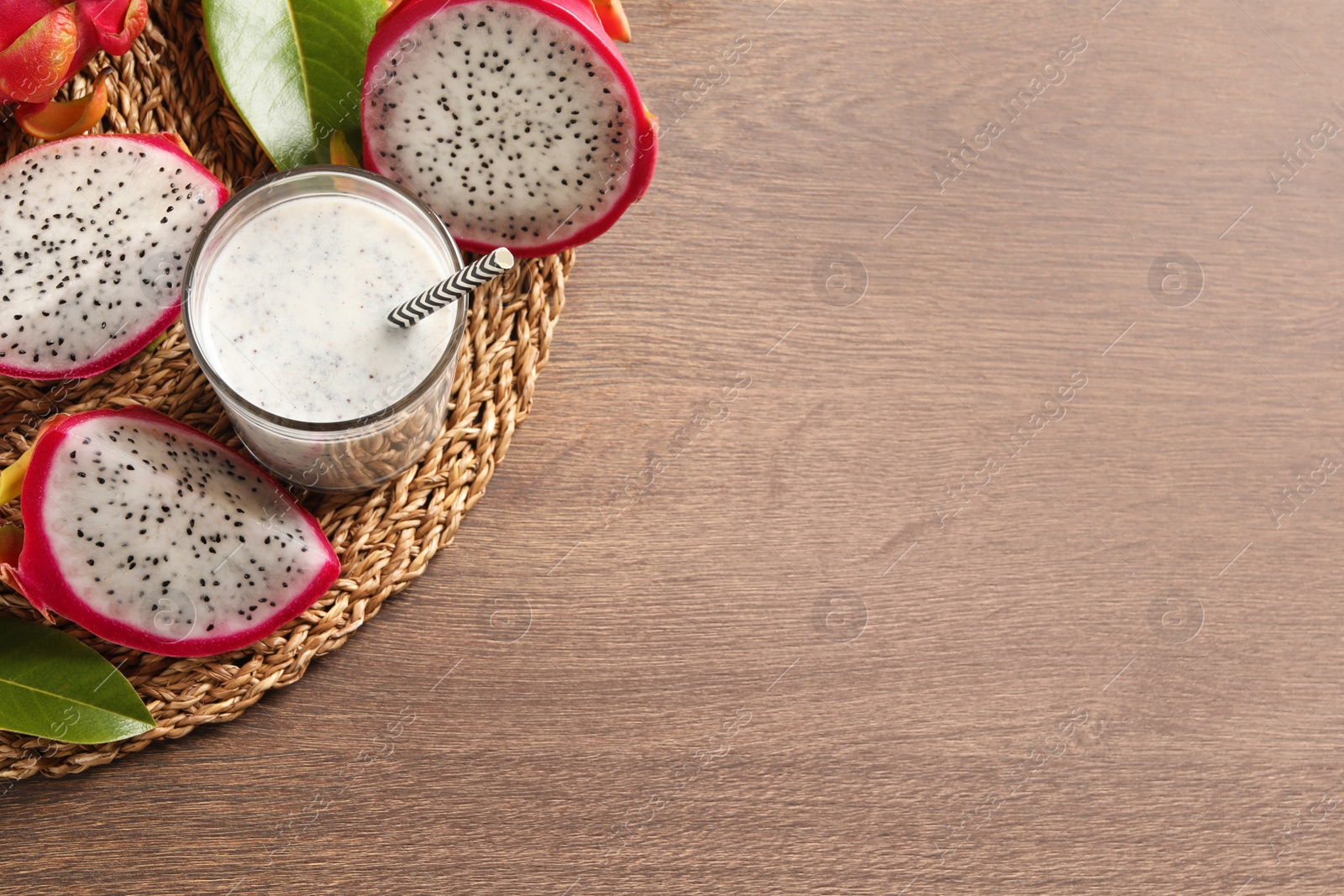 Photo of Delicious pitahaya smoothie and fresh fruits on wooden table, top view. Space for text