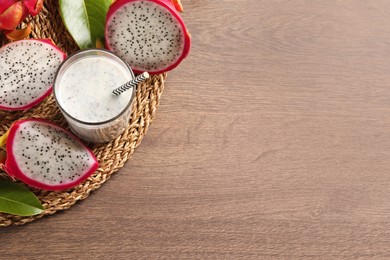 Photo of Delicious pitahaya smoothie and fresh fruits on wooden table, top view. Space for text