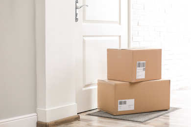 Photo of Parcels on rug near door. Delivery service