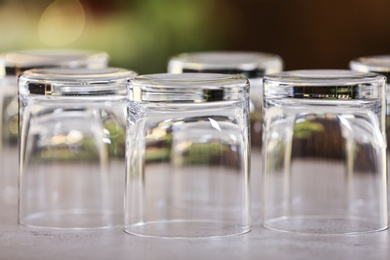 Set of empty glasses on grey table against blurred background