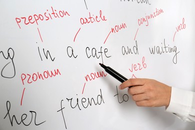 Photo of English teacher giving lesson near whiteboard, closeup
