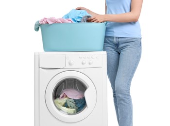 Woman with laundry near washing machine on white background, closeup