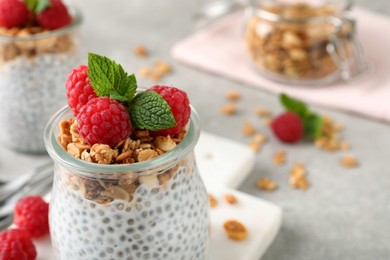 Photo of Delicious chia pudding with raspberries and granola in jar, closeup. Space for text