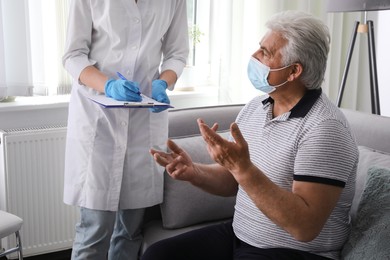 Doctor examining senior man with protective mask at nursing home