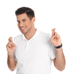 Photo of Man with crossed fingers on white background. Superstition concept