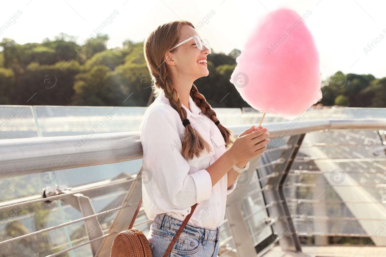 Photo of Young woman with cotton candy outdoors on sunny day