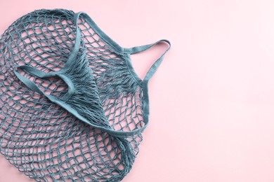 Photo of Blue string bag on pink background, top view. Space for text