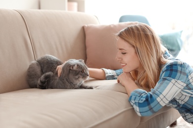 Photo of Young woman with her cute pet cat at home