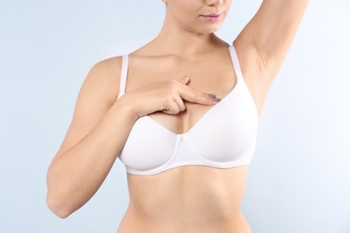 Photo of Woman checking her breast on white background, closeup