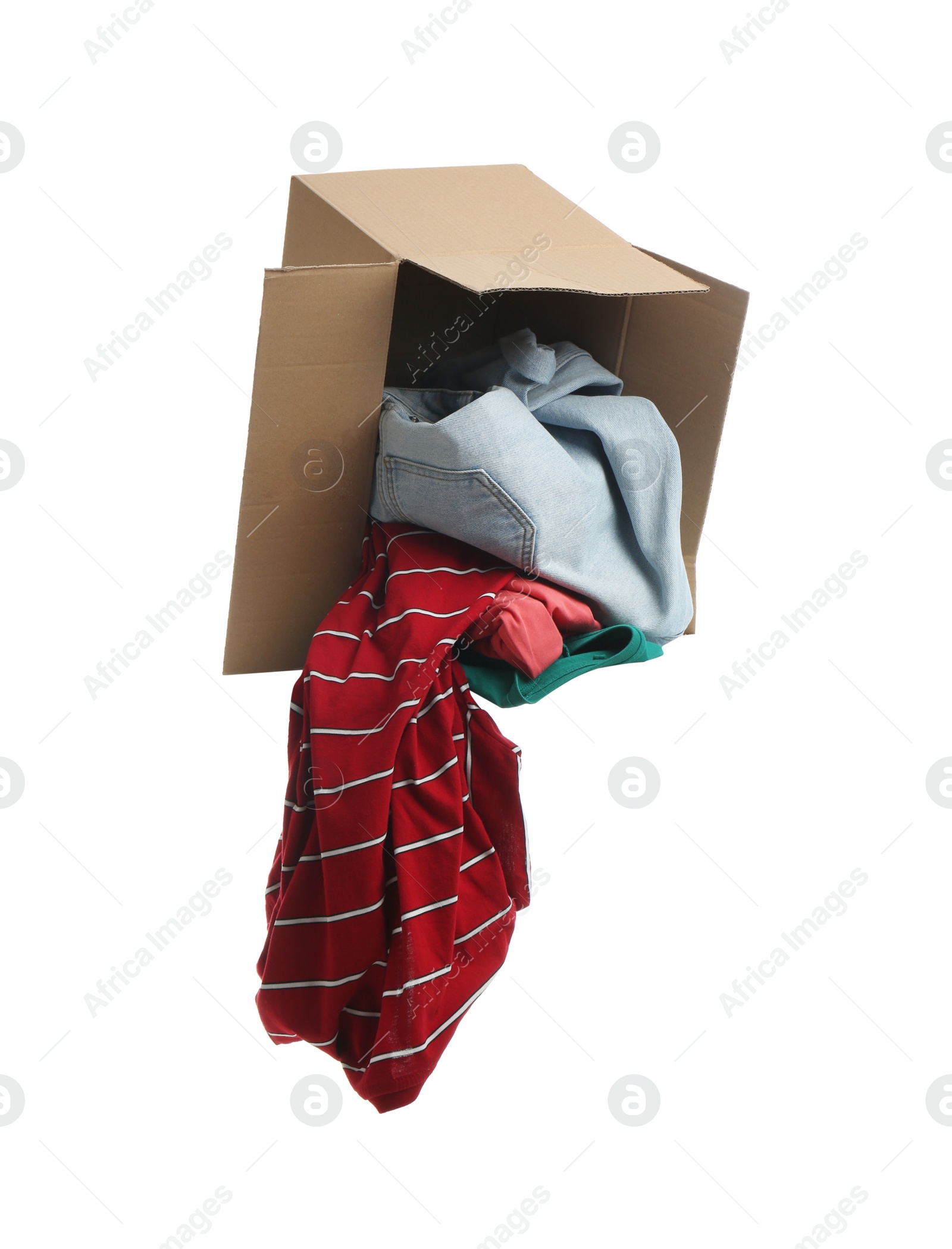 Photo of Overturned cardboard box with clothes isolated on white