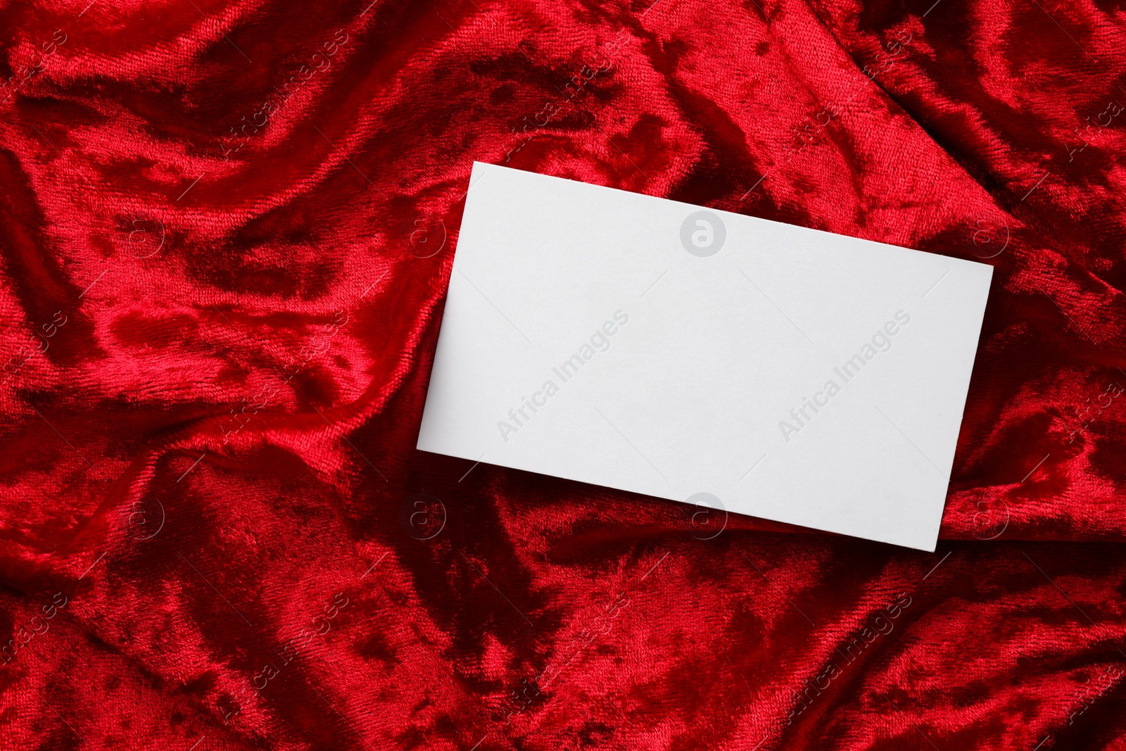 Photo of Blank business card on red fabric, top view. Mockup for design