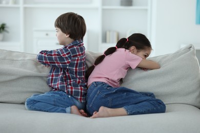 Photo of Upset brother and sister on sofa at home