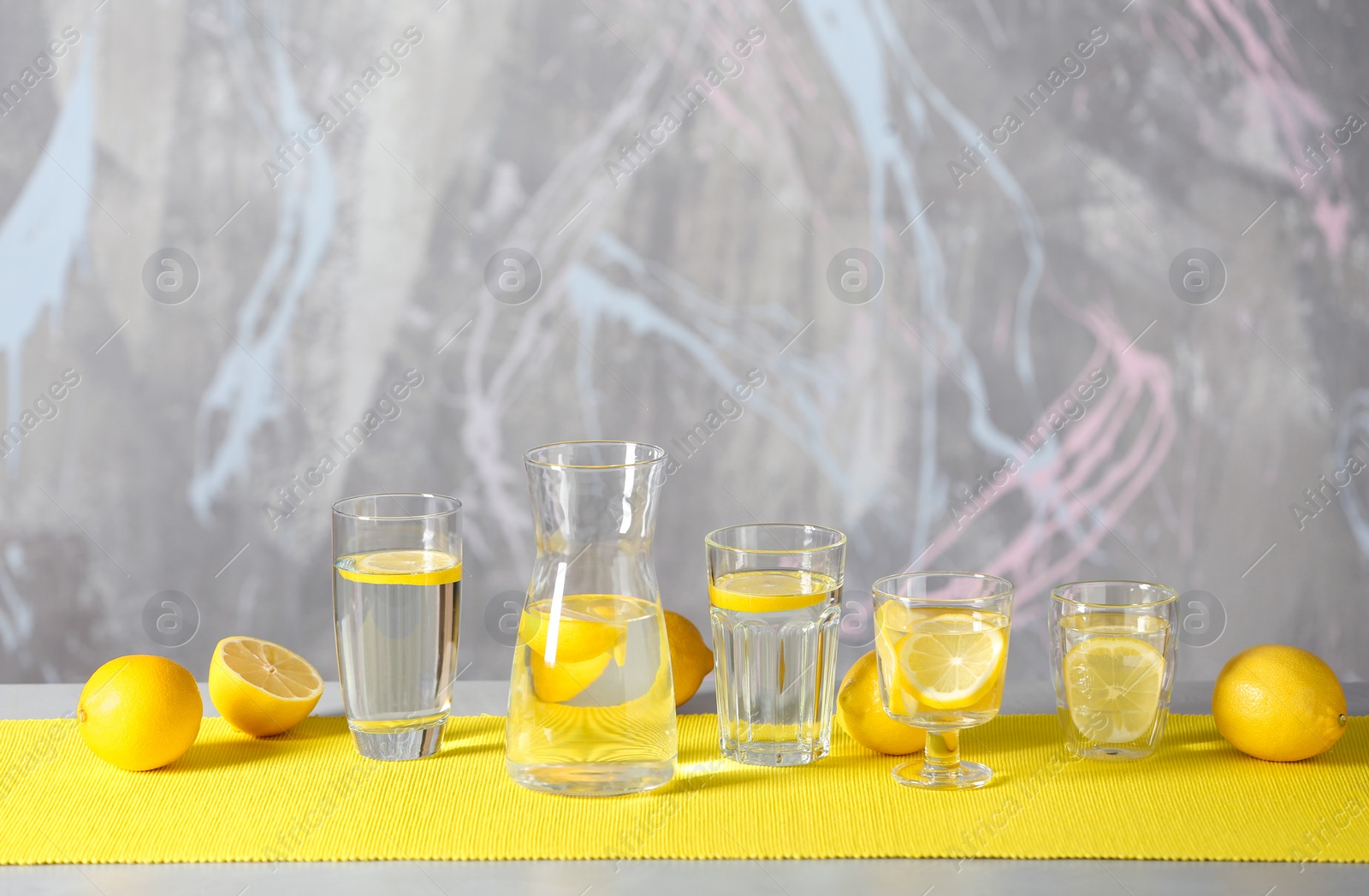 Photo of Glassware with water and slices of lemon on table