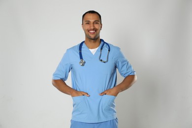 Doctor or medical assistant (male nurse) in uniform with stethoscope on light grey background