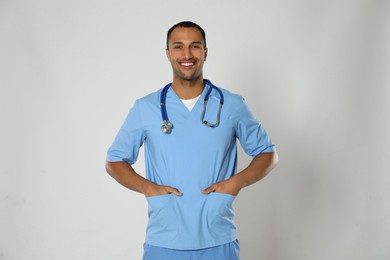 Photo of Doctor or medical assistant (male nurse) in uniform with stethoscope on light grey background