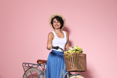 Photo of Portrait of beautiful young woman with bicycle on color background