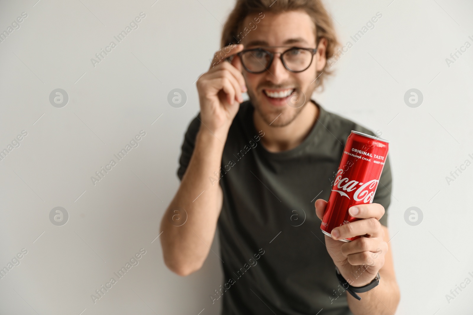 Photo of MYKOLAIV, UKRAINE - NOVEMBER 28, 2018: Young man with Coca-Cola can on white background