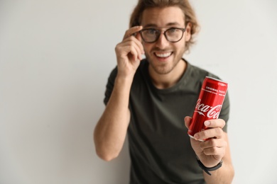 Photo of MYKOLAIV, UKRAINE - NOVEMBER 28, 2018: Young man with Coca-Cola can on white background