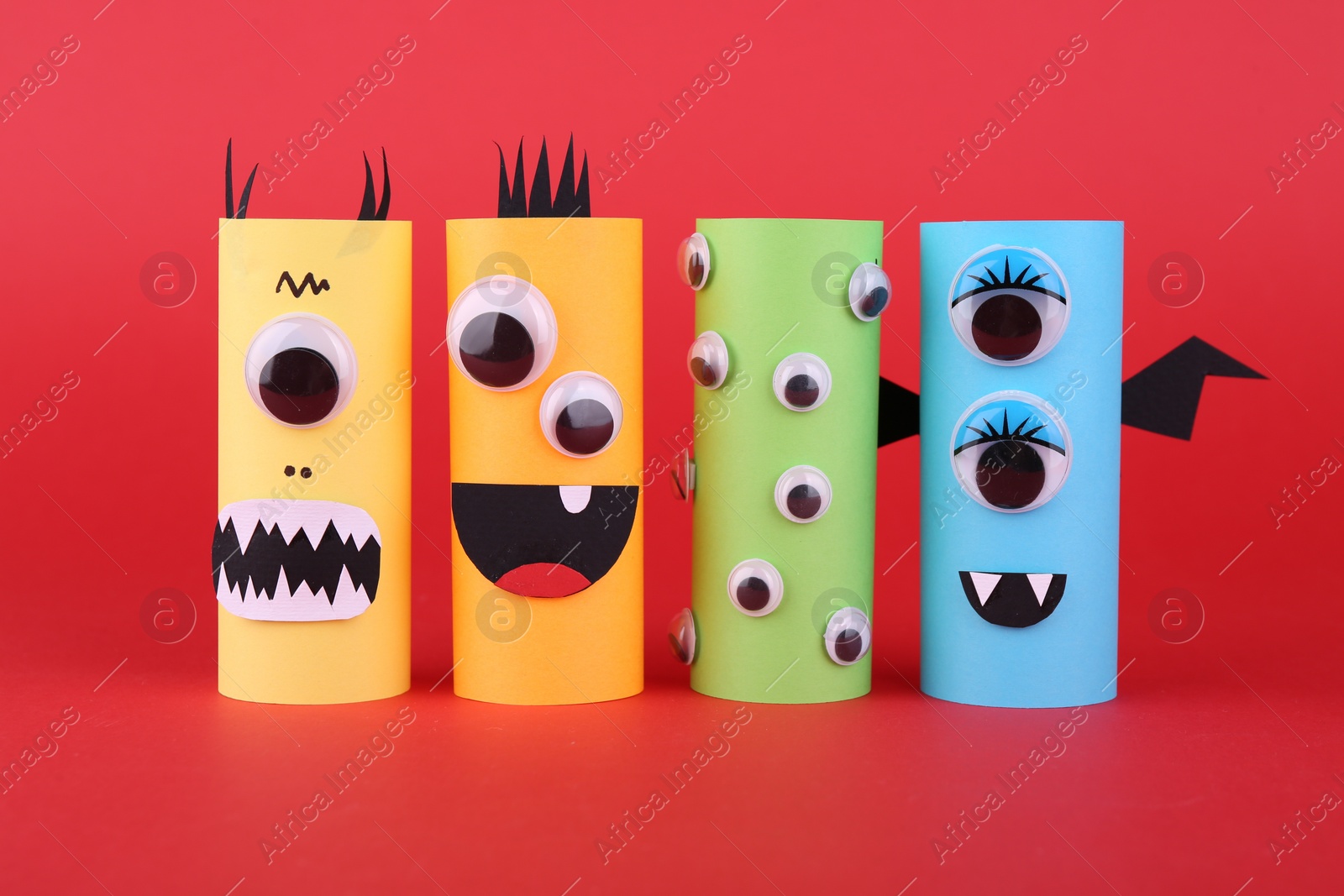 Photo of Spooky paper monsters on red background. Handmade Halloween decoration