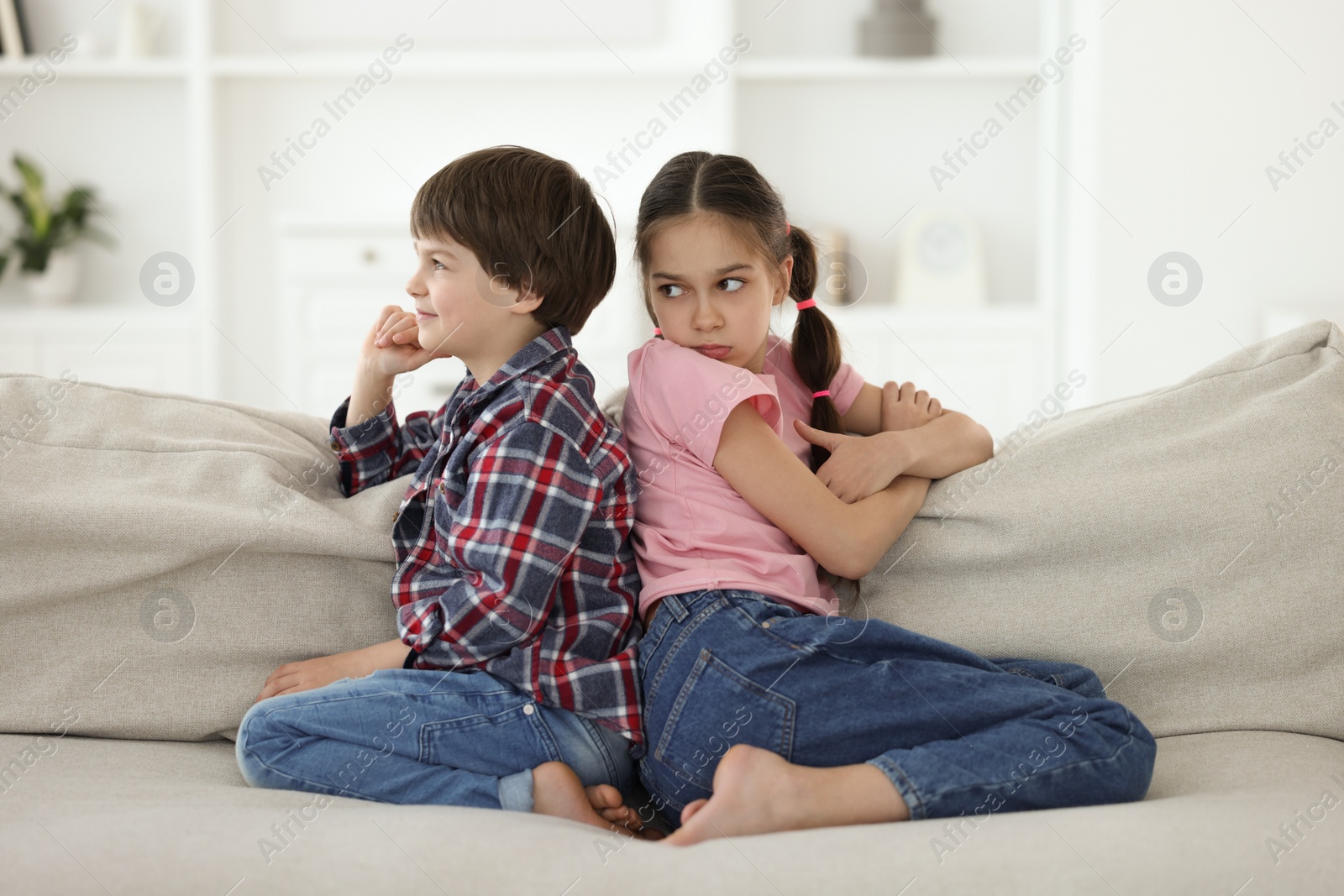 Photo of Upset brother and sister on sofa at home